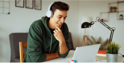 Homem usando fones de ouvido no escritório em frente o notebook