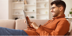 homem branco usando óculos e camisa marrom mexendo no tablet