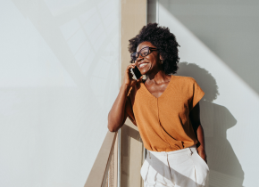 mulher negra usando óculos falando ao telefone