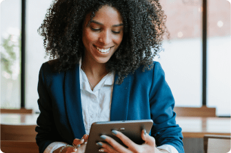 mulher negra com blazer azul segurando um tablet.