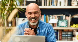 Homem sorrindo olhando para um notebook