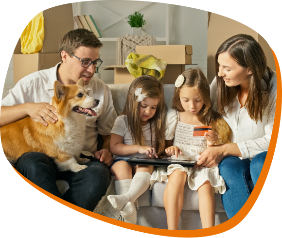 um homem segurando um cachorro da raça corgi, e uma mulher olhando para um tablet com duas crianças.